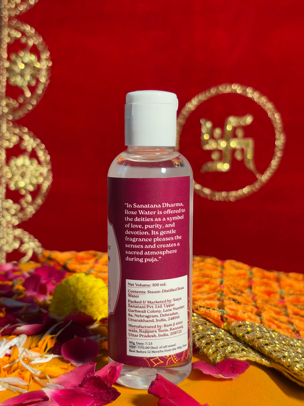 Side view of Satya Sanatani Rose Water bottle, puja background