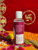 Side view of Satya Sanatani Rose Water bottle, puja background
