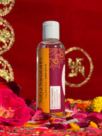 Side view of Satya Sanatani Rose Water bottle, puja background