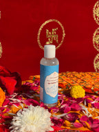 Bottle of Satya Sanatani Pure Gangajal with puja flowers and Swastik backdrop