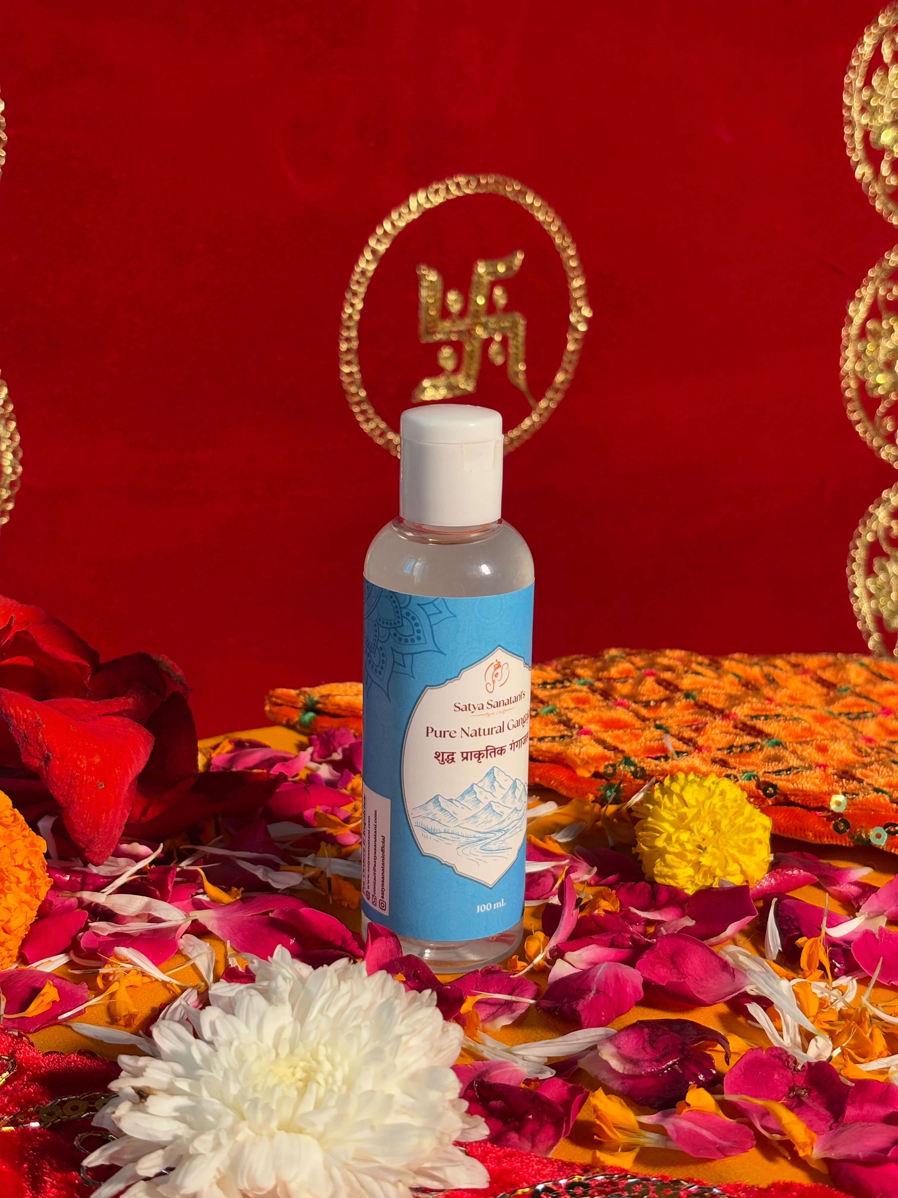 Bottle of Satya Sanatani Pure Gangajal with puja flowers and Swastik backdrop