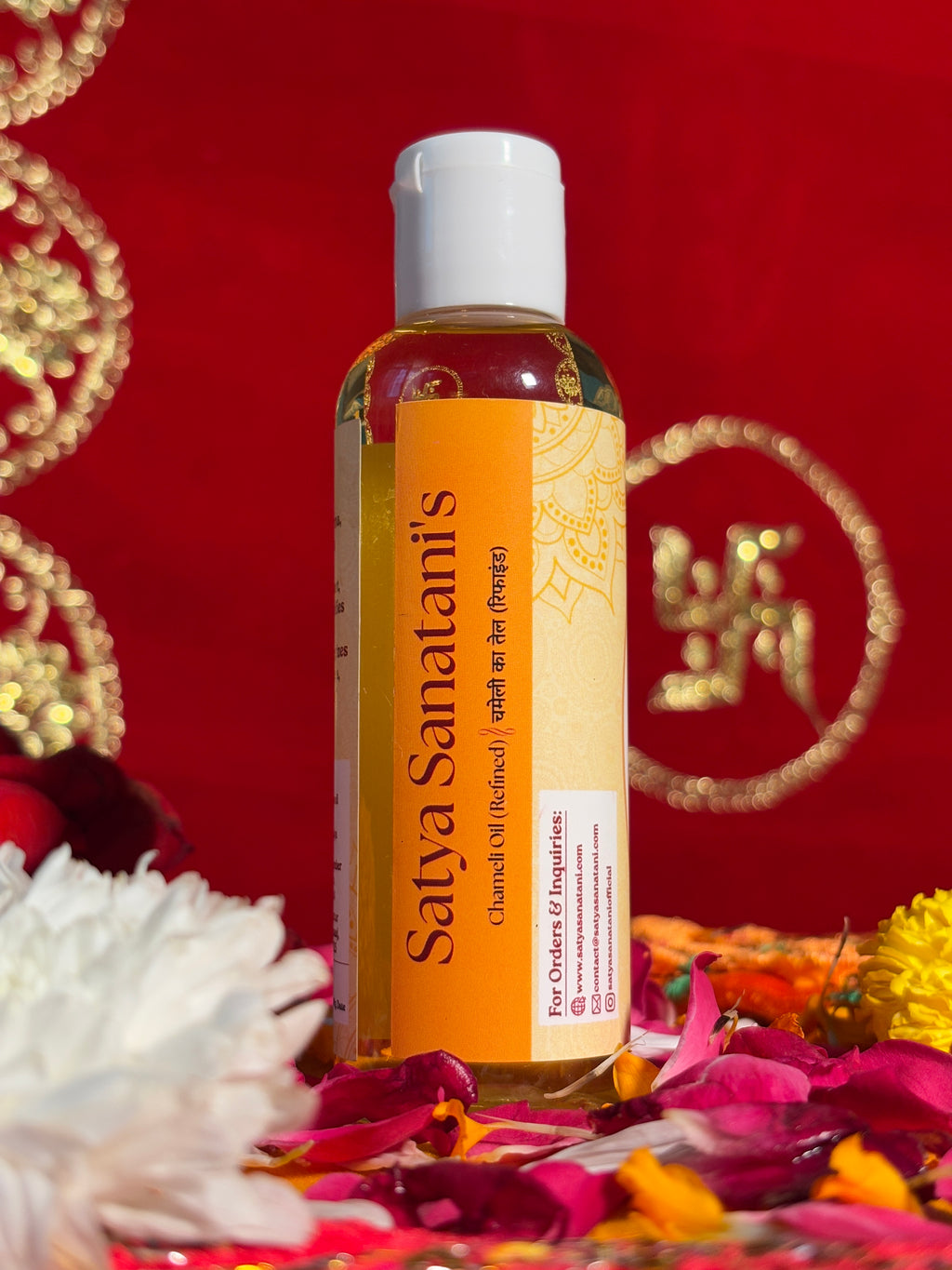 Chameli Oil bottle displayed with marigold and rose petals for aarti rituals