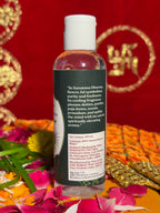 Side view of Kewra Jal bottle with petals and marigold