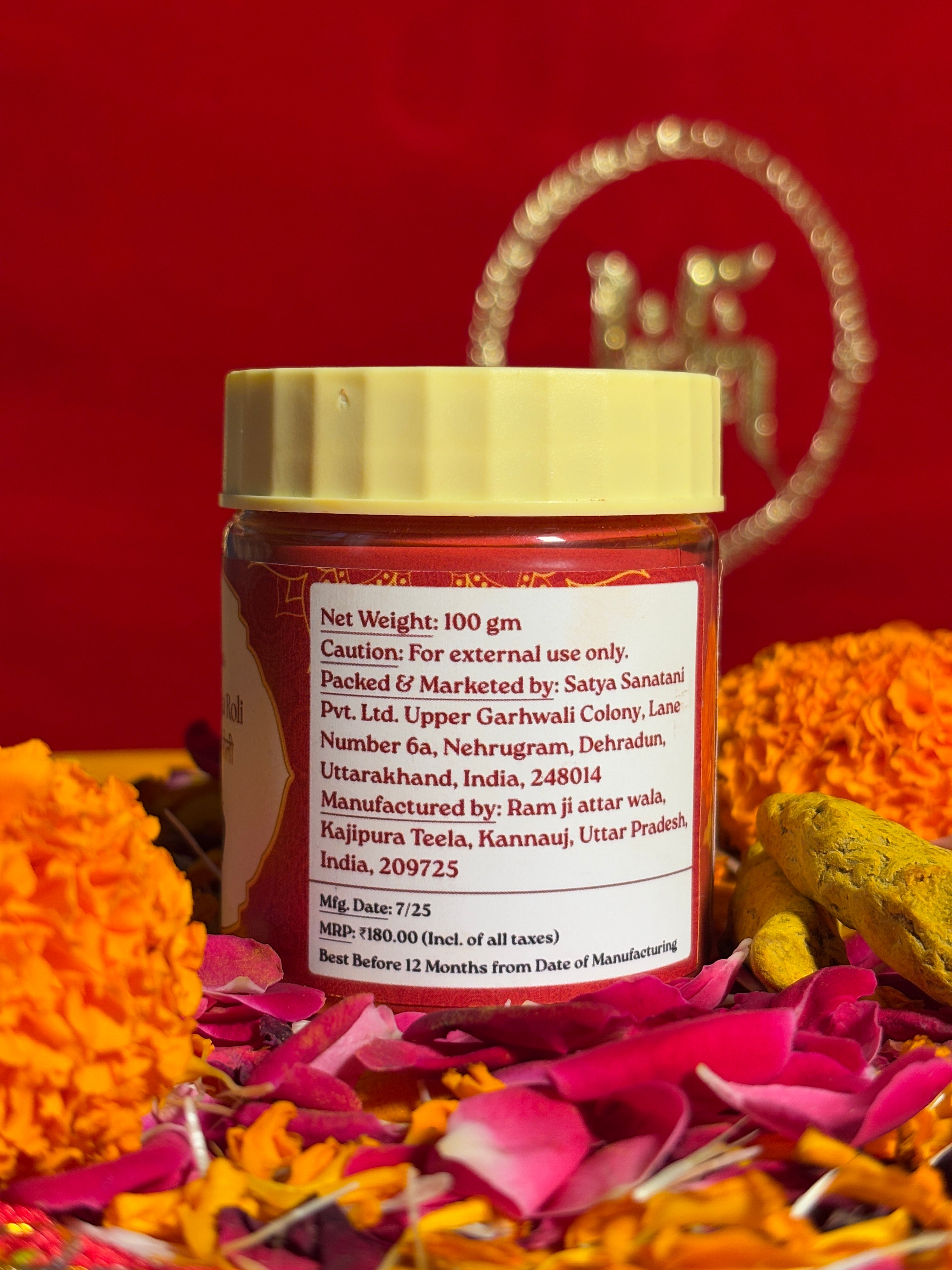 Roli jar displayed with marigold and rose petals for puja