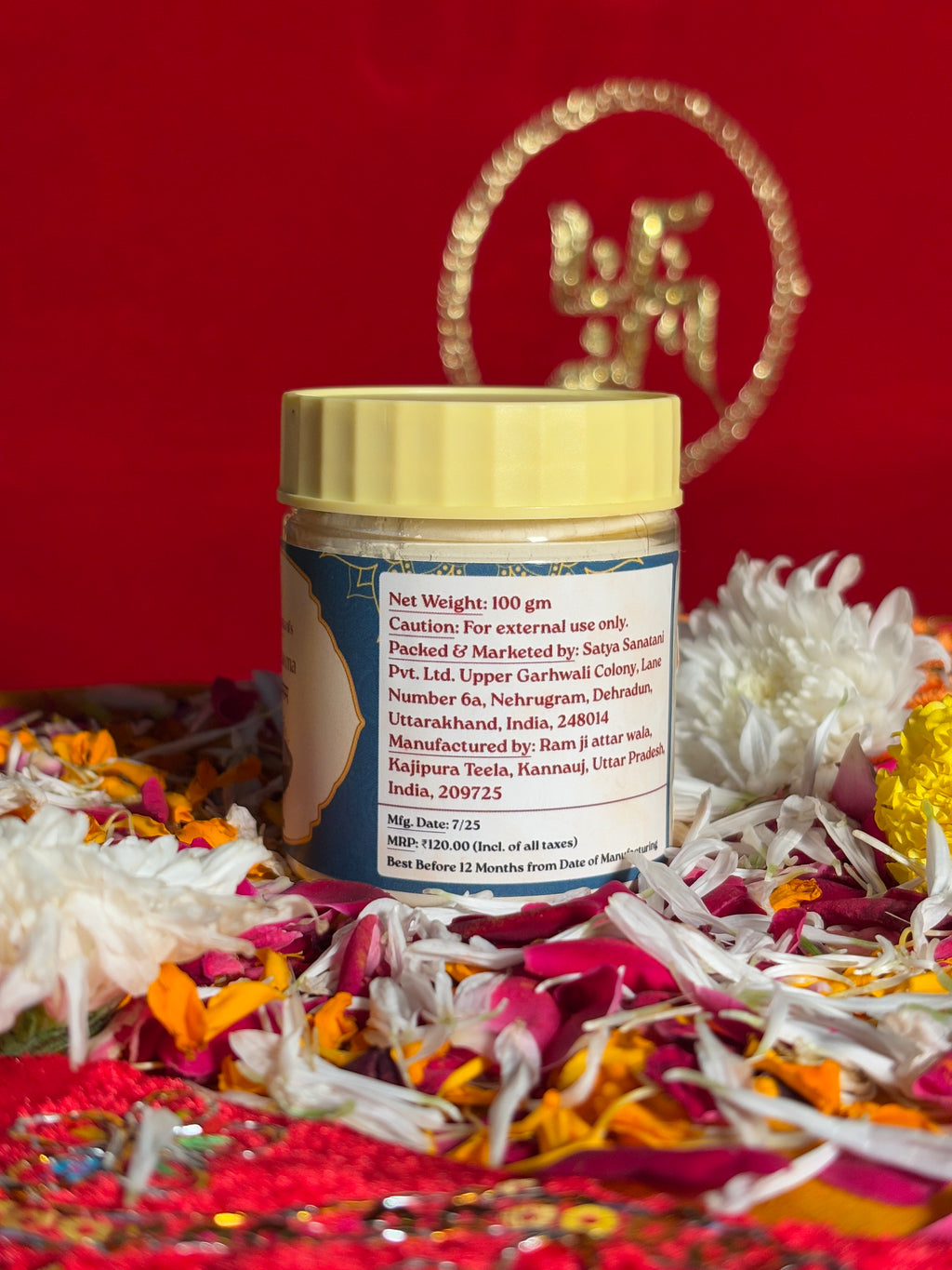 Open jar of sacred ash displayed with marigold and rose petals