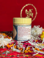 Open jar of sacred ash displayed with marigold and rose petals