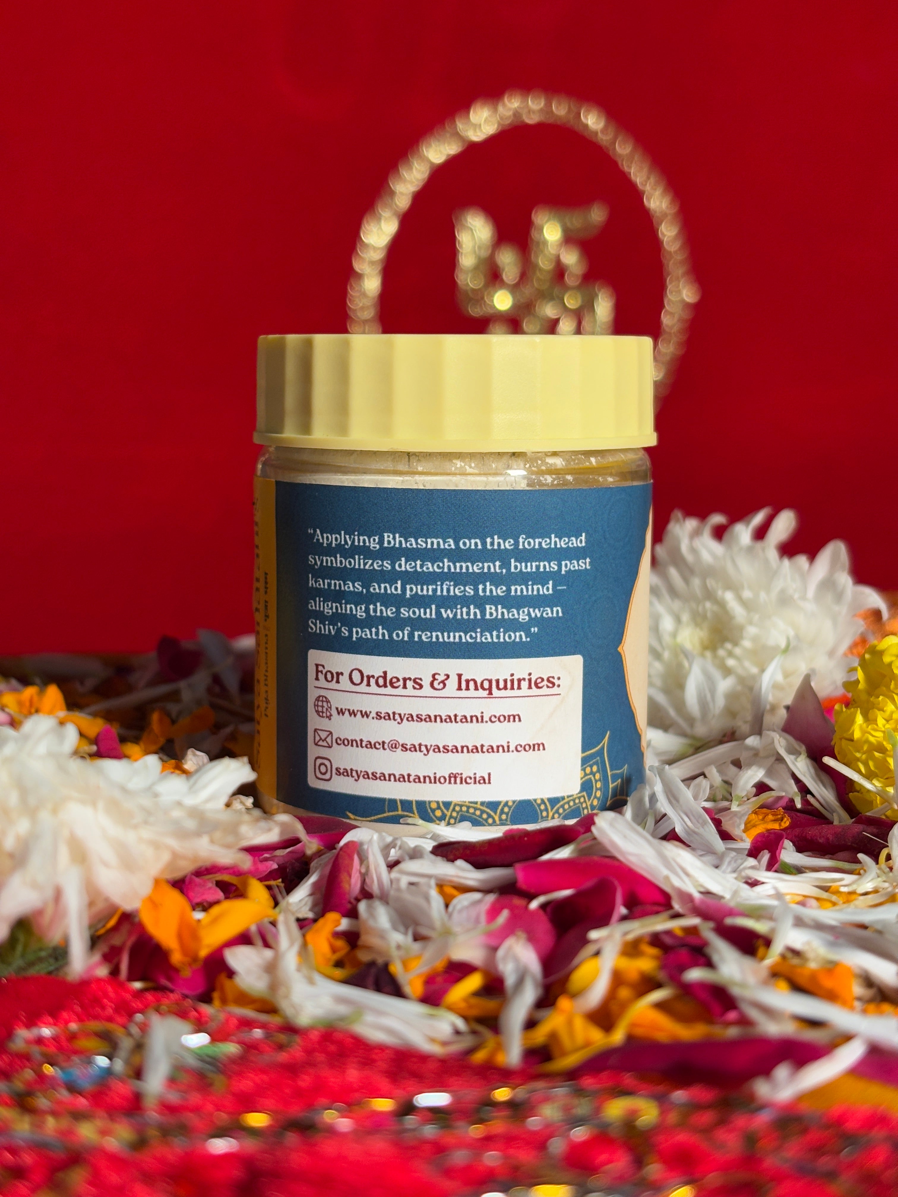 Side view of Puja Bhasma jar with red background and floral decor