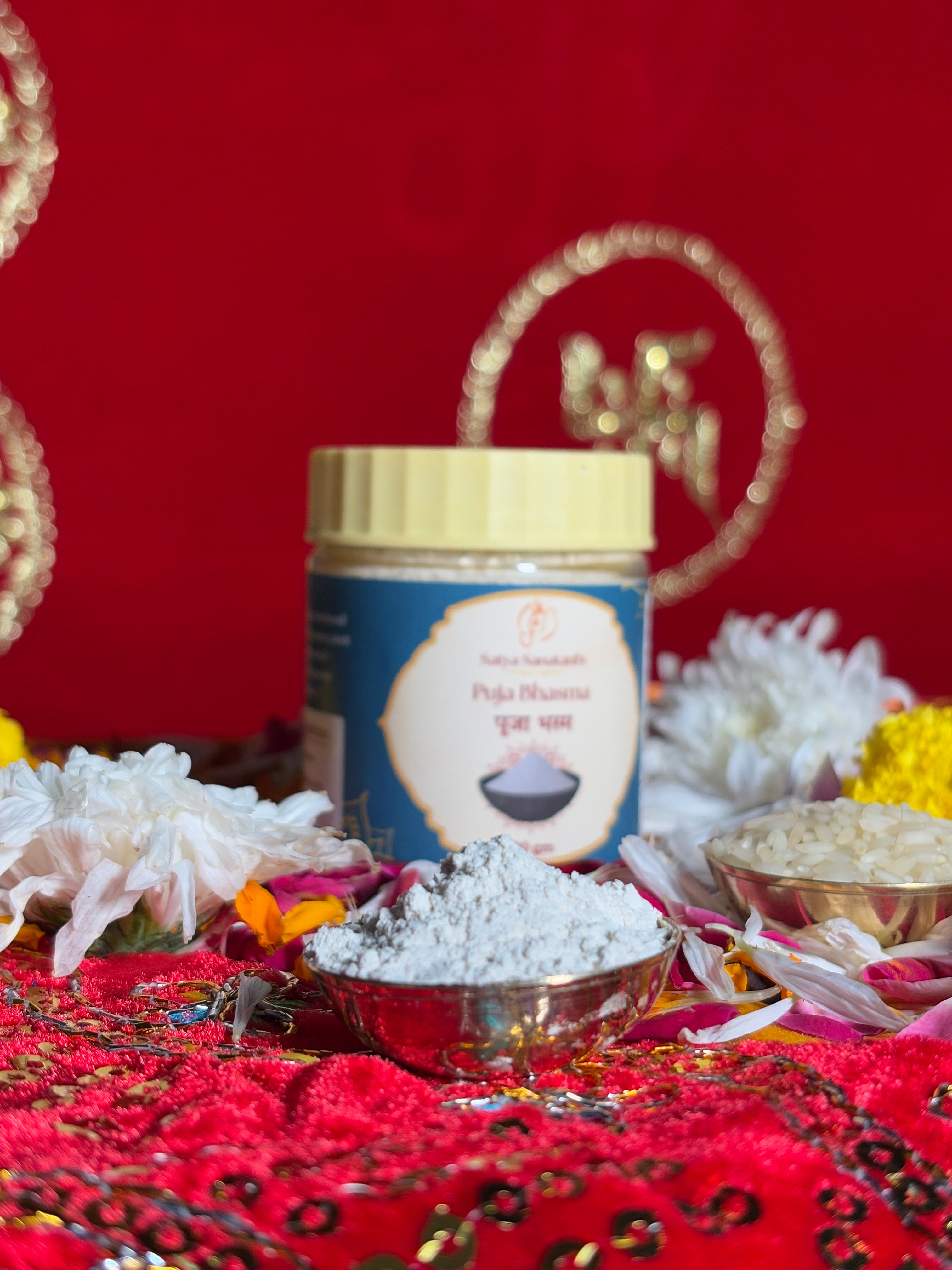 Sacred ash container placed on saffron-red altar cloth with marigold and rose petals for rituals