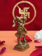 Decorative setup of brass Sanjeevani Hanuman Ji idol with flowers and Swastik backdrop
