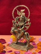 Close-up of Durga brass statue with fierce expression, lion and weapons