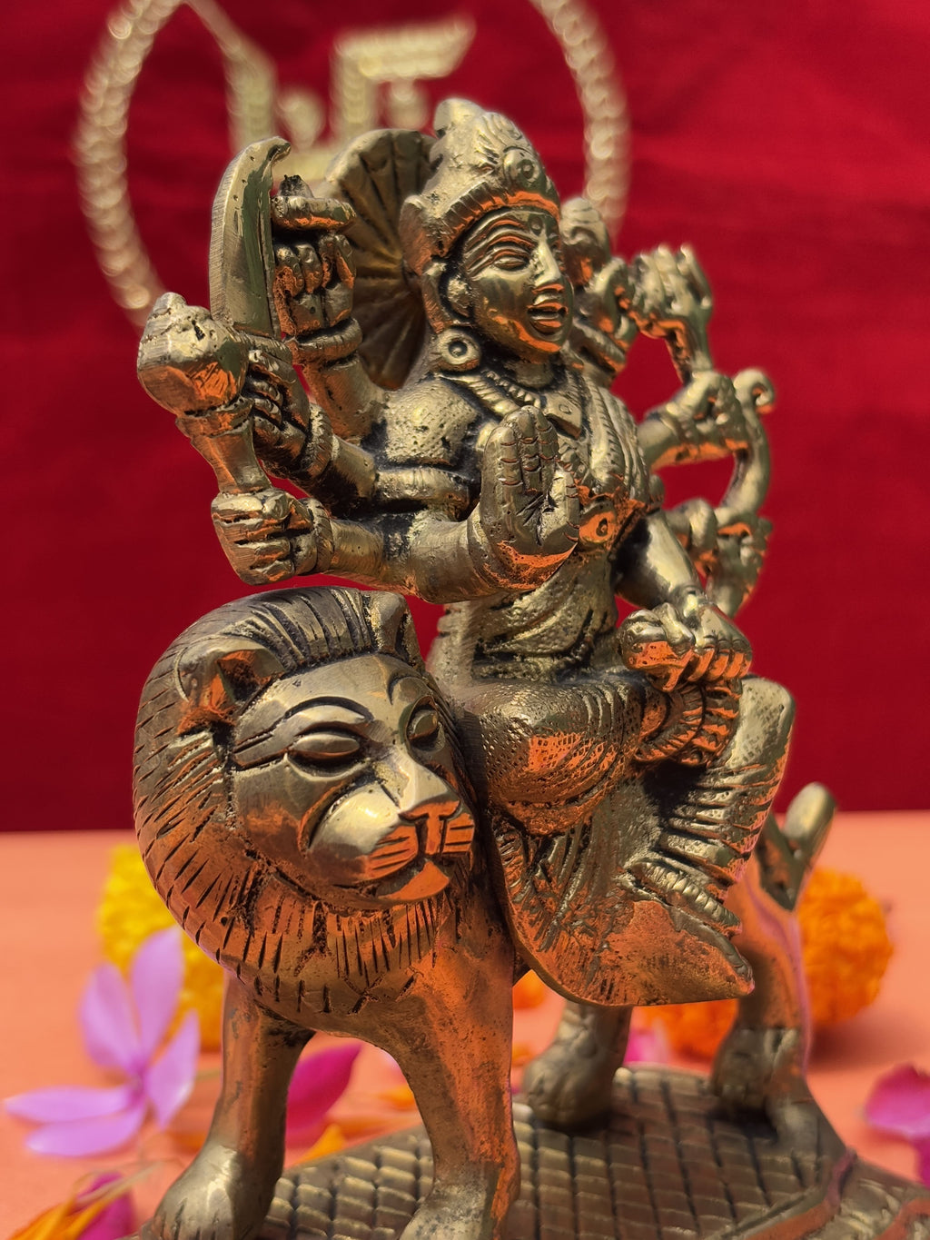 Decorative shot of Maa Durga brass murti with marigold and rose petals